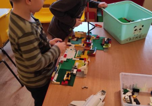 Wojtek G. z Radkiem tworzą budowle z klocków Lego.